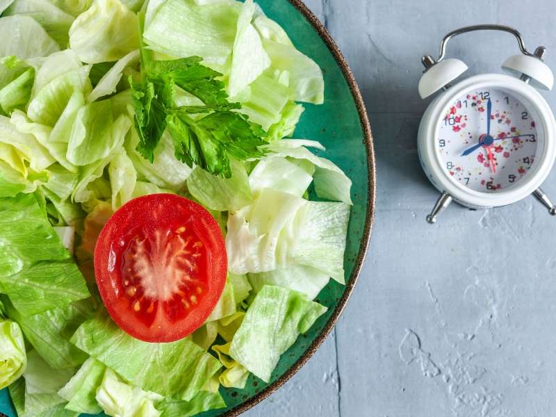 Autophagie - Teller mit Salat und einer Uhr daneben